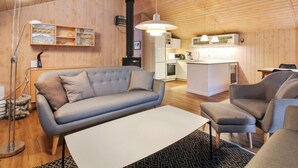 A cozy, modern living room with a sofa, a dining table, and a kitchen area. - "Elsemaria" - 1.3km from the sea by Interhome (Løkken)
