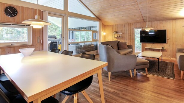 A spacious living area with a wooden ceiling, large windows, a dining table, and a flat-screen TV. - "Elsemaria" - 1.3km from the sea by Interhome (Løkken)