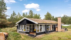 A modern cabin with a porch, large windows, and a chimney. - "Gloria" - 2.5km from the sea by Interhome (Blokhus)
