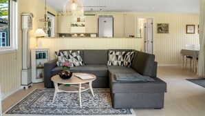 A cozy living room with a grey sectional sofa, a small round table, and a patterned rug.