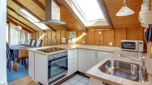 Een kleine keuken met een inbouwoven, een magnetron en een spoelbak.