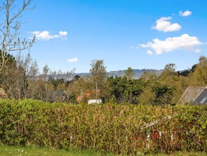 A residential area with houses surrounded by dense vegetation and a clear blue sky.