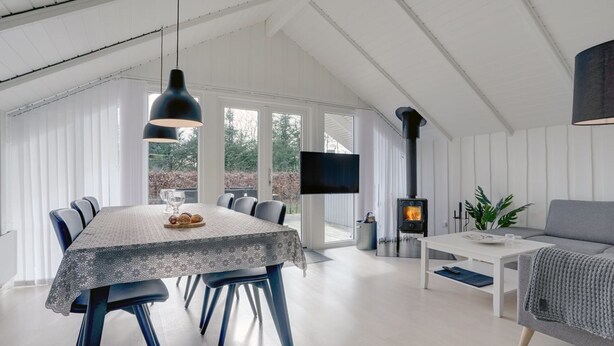 A modern interior with a dining area, a sofa, and a fireplace.