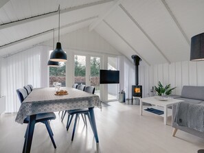 Un interior moderno con una zona de comedor, un sofá y una chimenea.