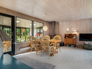 Een modern interieur met een eethoek, een open haard en een televisie.