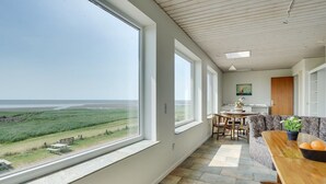 A modern kitchen with large windows, a dining area, and a view of the beach. - "Stilla" - 35km from the sea by Interhome (Højer)