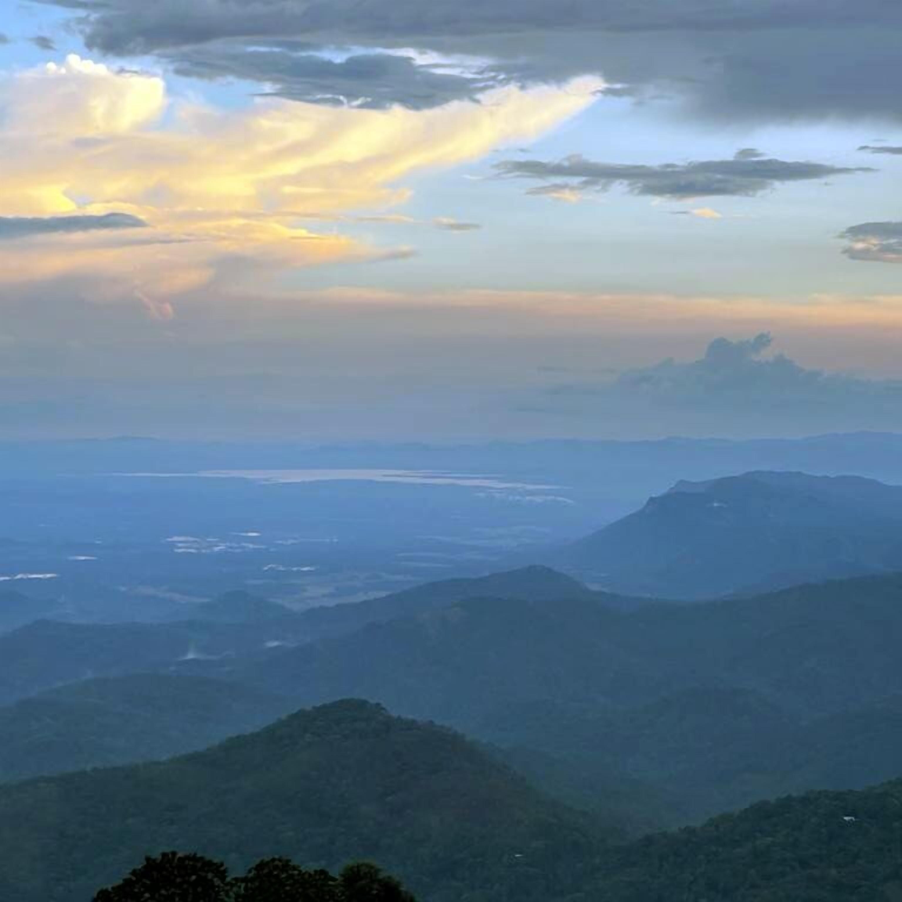 Un paisaje montañoso con vista a un río y colinas distantes.