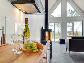 Et moderne køkken med en vinflaske, glas og druer på en træplade.