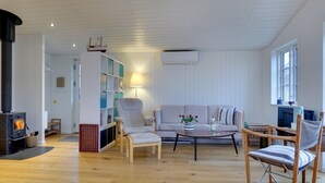 A cozy living room with a sofa, armchairs, a coffee table, and a fireplace. - "Sofine" - 250m from the sea by Interhome (Løkken)