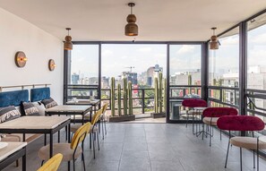 Enjoy a panoramic city view from this open-plan dining area with a mix of seating options and minimalist decor.