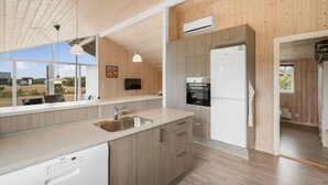 A modern kitchen with wooden cabinets, a stainless steel sink, and a built-in oven. - "Clement" - 500m to the fjord by Interhome (Skjern)