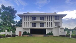 A modern two-story house with a flat roof, large windows, and a covered garage. - Mayur Gardens (Sonapur)