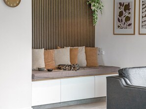 A seating area with a sofa, cushions, a small table, and a plant. - "Asel" - 350m from the sea by Interhome (Grenaa)