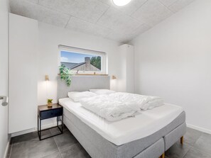 A modern bedroom with a bed, bedside tables, a window, and a view of the outside. - "Asel" - 350m from the sea by Interhome (Grenaa)