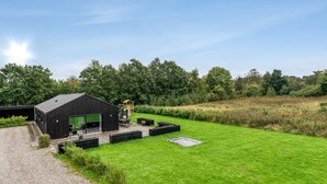 Un bâtiment moderne doté d’un grand garage ouvert et d’une pelouse bien entretenue.