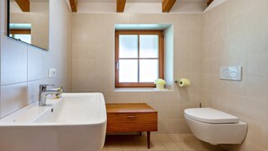 A bathroom with a sink, toilet, and window. - Studio Apartment 'Urthalerhof Landhaus' with Mountain View, Shared Garden and Wi-Fi (Olang)