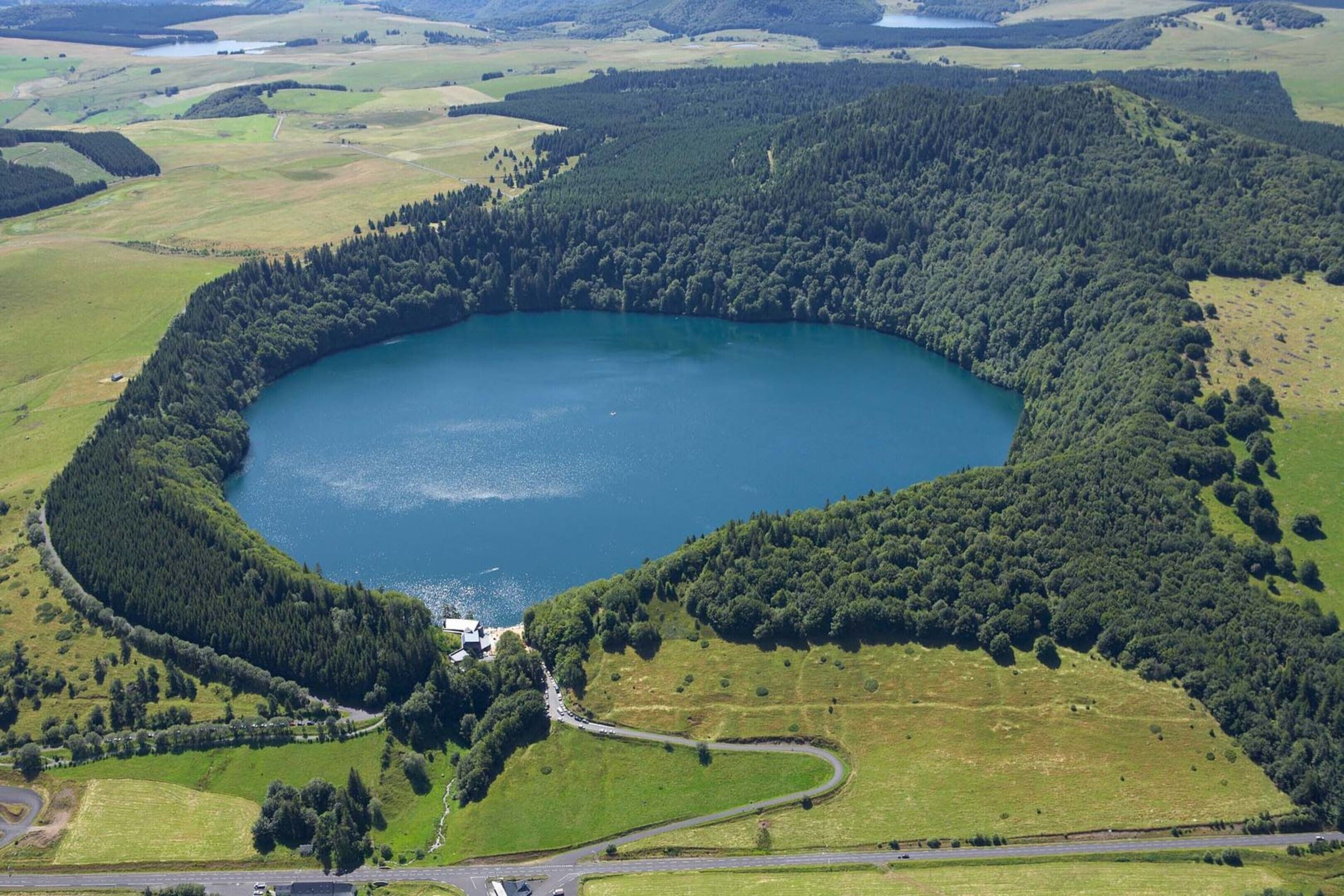 Vista aérea de um lago rodeado por colinas arborizadas.