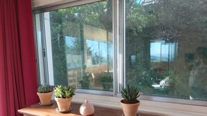 Un aparador de madera con cajones y una ventana con plantas en macetas.