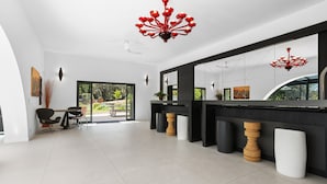 Ein modernes Interieur mit einem großen Spiegel, schwarz-weißem Dekor und einem roten Kronleuchter.