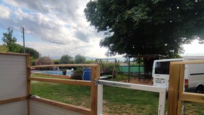 Zona exterior tancada amb piscina, balancà i una furgoneta blanca aparcada a prop.
