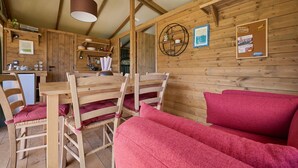 Un interno in legno con un tavolo da pranzo, sedie e un divano rosso.