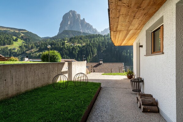 A building with a concrete exterior, a wooden ceiling, and a view of mountains.