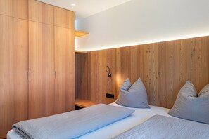 Une chambre moderne avec un lambris en bois, un lit avec des oreillers et une table de chevet.
