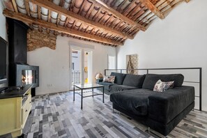 Una sala de estar con chimenea, un sofá, una mesa de centro y una zona de cocina.