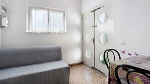 A room with a bed, a window, a door with mirrors, and a table with chairs. - Apartment "Casa Lavanda vicino al Mare" with Private Terrace (Massa)