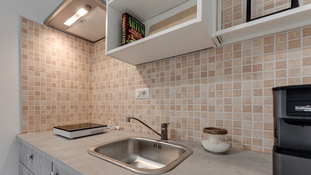 A kitchen with a sink, a toaster, and a shelf with books. - Apartment 'Ursa' with Shared Garden, Wi-Fi and Air Conditioning (Calenzano)