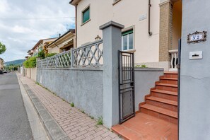 A residential building with a gated entrance, a staircase, and a street view.