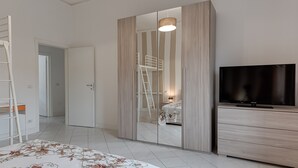 A bedroom with a bed, a wardrobe, a TV, and a ladder. - Apartment "Giada" with Private Terrace & Wi-Fi (Calenzano)