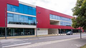 A modern building with a red facade, large windows, and a sign reading 'DESIGN CAMPUS.' - Apartment "Giada" with Private Terrace & Wi-Fi (Calenzano)