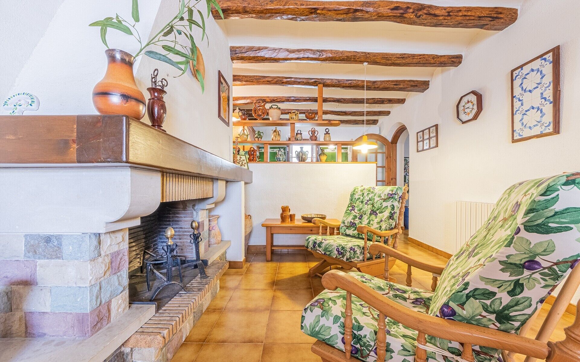 Un ambiente acogedor con chimenea, muebles de madera y una colección de objetos decorativos en estantes.