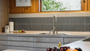 Una cocina de diseño moderno, con un lavamanos grande, una encimera de madera y un bol de fruta.