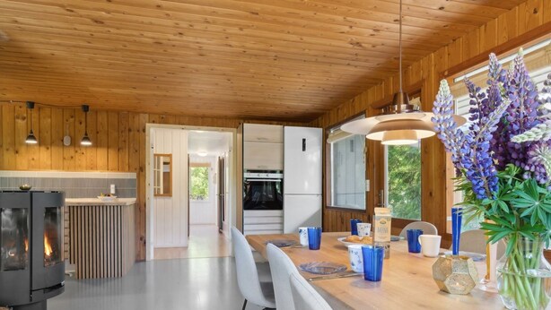Una cocina moderna con paredes de madera, una isla central y un horno empotrado.