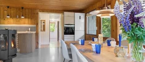 Une cuisine moderne avec des murs en bois, un îlot central et un four encastré.