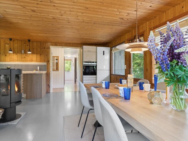 Een moderne keuken met houten wanden, een centraal eiland en een ingebouwde oven.
