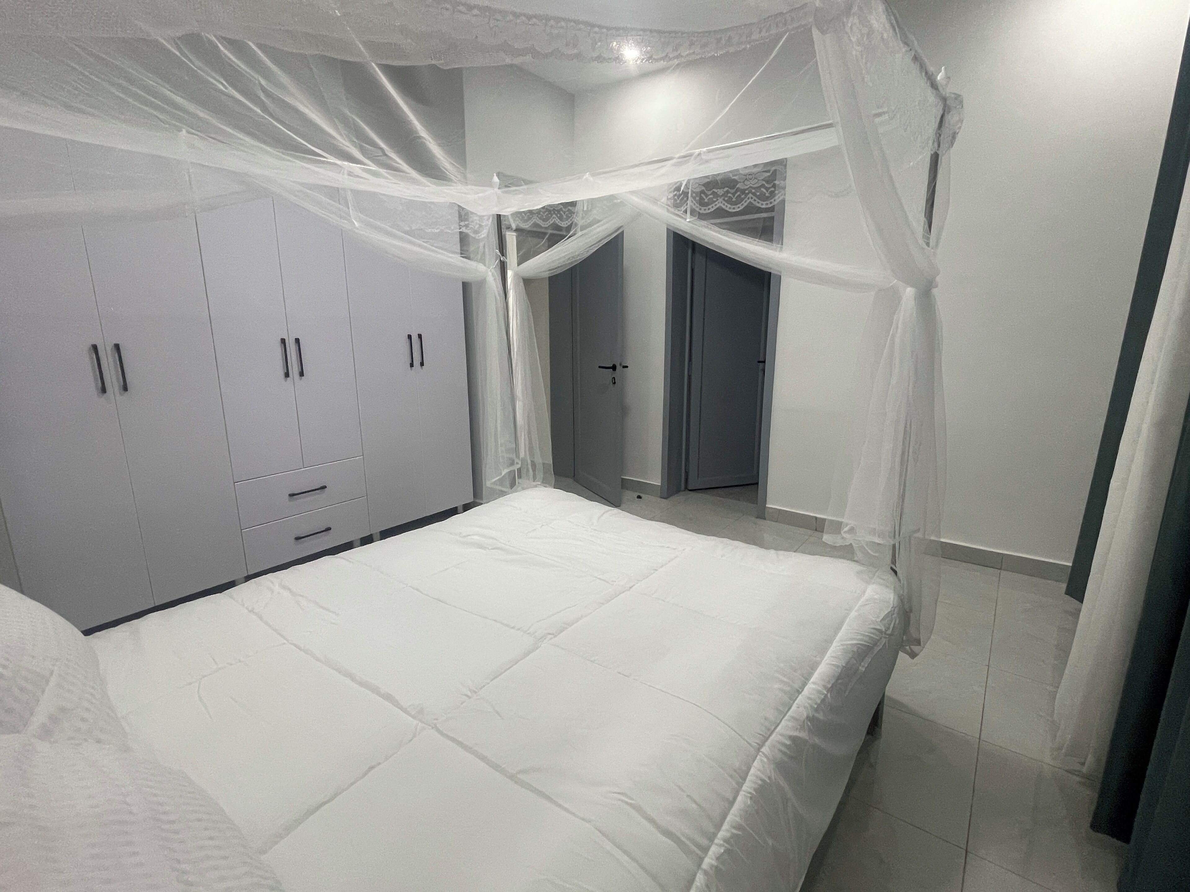 Un dormitorio con cama, armario y puerta que da a otra habitación.