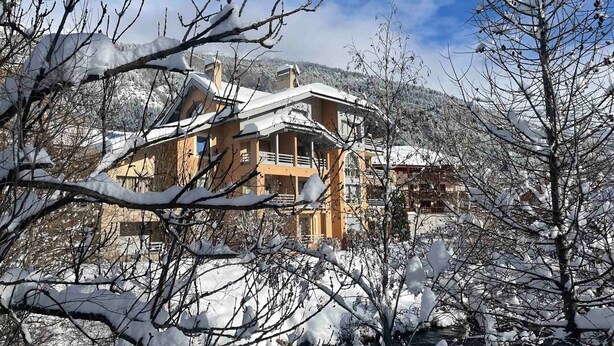 A large, multi-story building with a snow-covered roof and surrounding trees. - Spacious apartment 8 guests, south-facing balcony, parking (La Salle-les-Alpes)