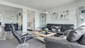 A modern living room with a black leather sofa, a black leather chair, a wooden coffee table, and a dining area with a checkered floor. - "Maura" - 2.3km from the sea by Interhome (Rømø)