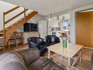 A modern living space with a wooden staircase, a flat-screen TV, a dining area with two chairs, and a kitchen in the background. - "Nilaus" - 2.3km from the sea by Interhome (Rømø)