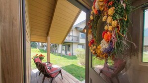 Eine Holzterrasse mit Sitzgelegenheiten im Freien und Blick auf ein Gebäude mit einer Veranda.