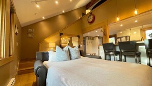 Ein Schlafzimmer mit einem großen Bett, einer Sitzecke mit einer Couch und einem Essbereich mit Stühlen und einem Tisch.