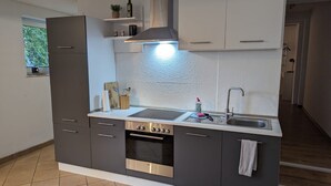 Eine moderne Küche mit Einbauofen, Edelstahlspüle und Dunstabzugshaube.