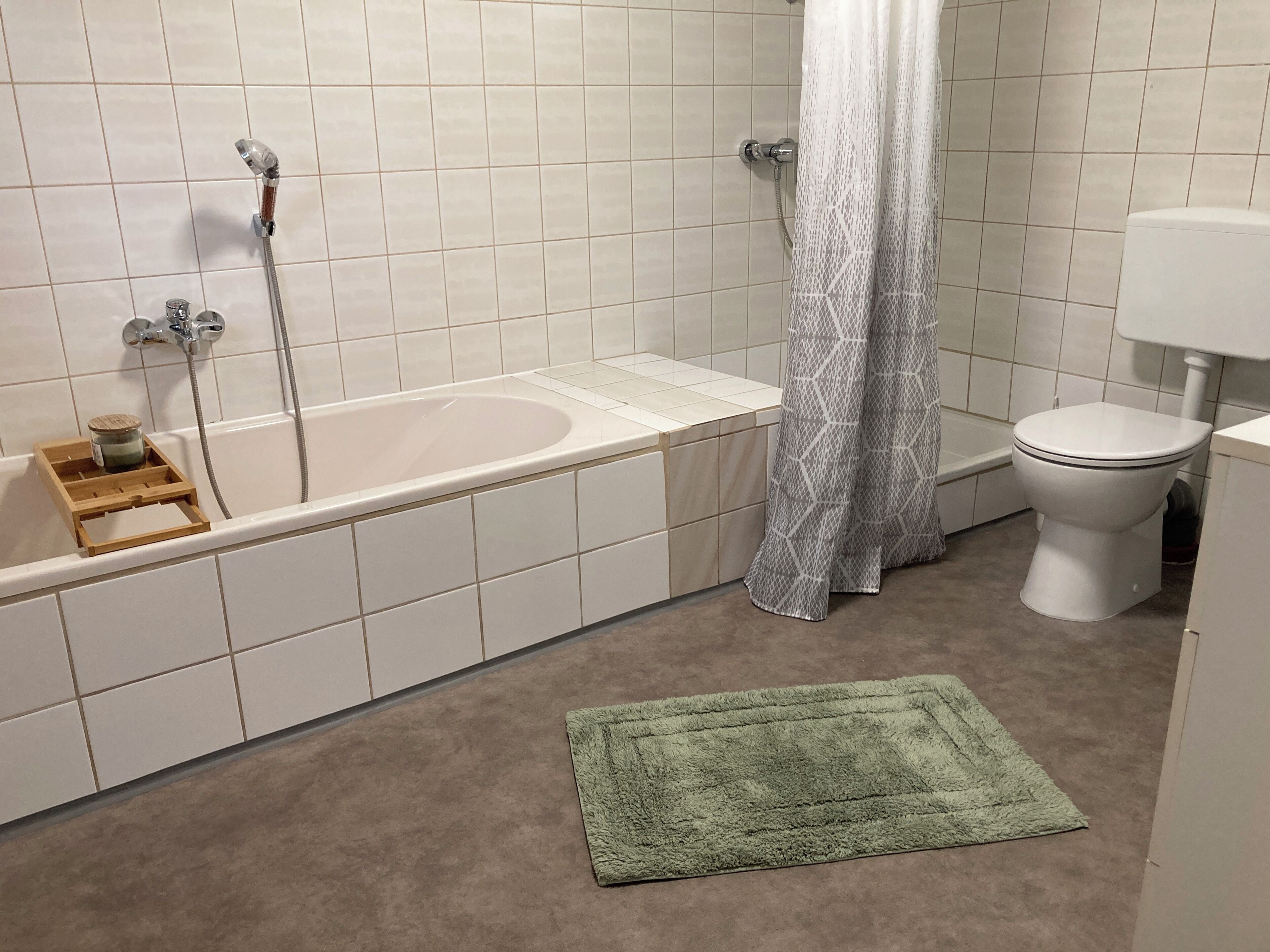 Een badkamer met een bad, toilet en douchegordijn.