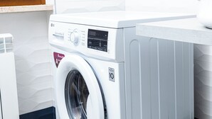 A front-loading washing machine with a digital display and a control knob. - Gallo's City Rooms (Termoli)