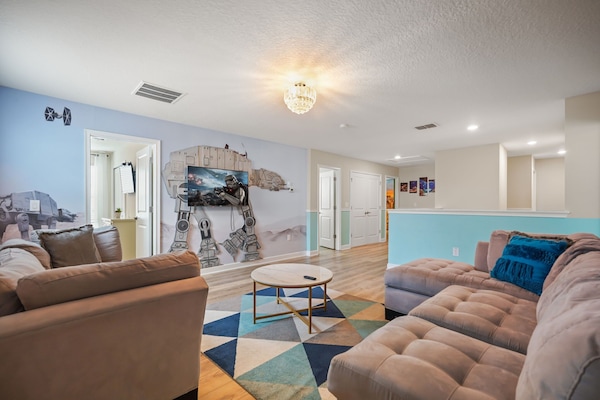 Experience epic movie nights in this themed living room with a cozy sectional and immersive decor.