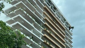 Un edificio de varios pisos con balcones, base de piedra y techo inclinado.