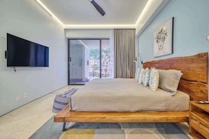 A modern bedroom with a large bed, a flat-screen TV, and a view of the outside.